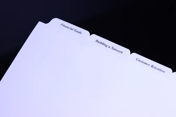 Printed financial advisor index tabs on white index stock at an angle