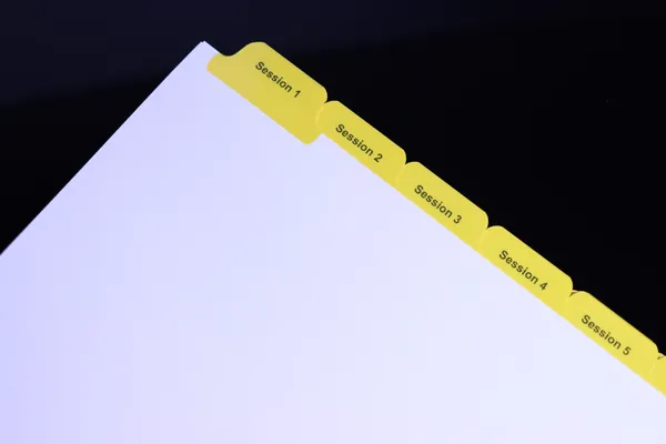 Numbered Session 1 through 7 yellow index tabs in a training manual